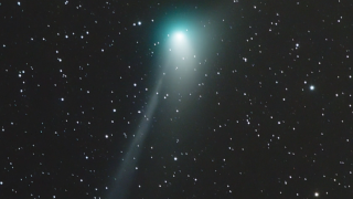 green comet visible against a backdrop of stars